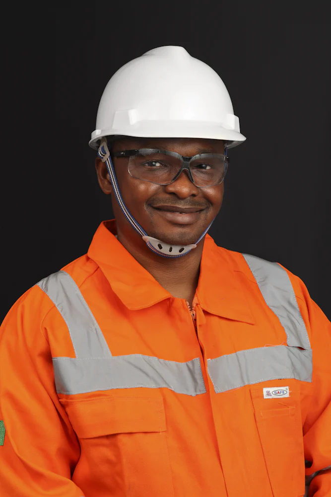 Smiling engineer wearing a hard hat, safety glasses and high-visibility clothing
