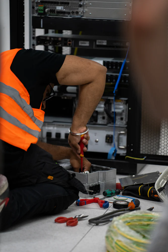 Technician in high-visibility clothing installing network equipment