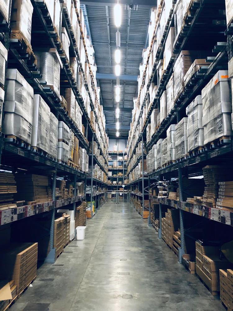 Long warehouse aisle lined with racks of boxed stock